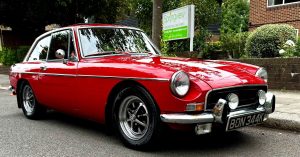 Bright red vintage MG parked outside Springview Care Home in Enfield during the Summer Festival.