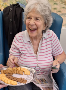 Resident at Spring Lane smiling while enjoying Diwali biscuits and treats during the celebration.