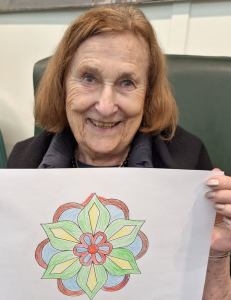 Resident proudly holding her colourful Diwali mandala art created during the celebration.