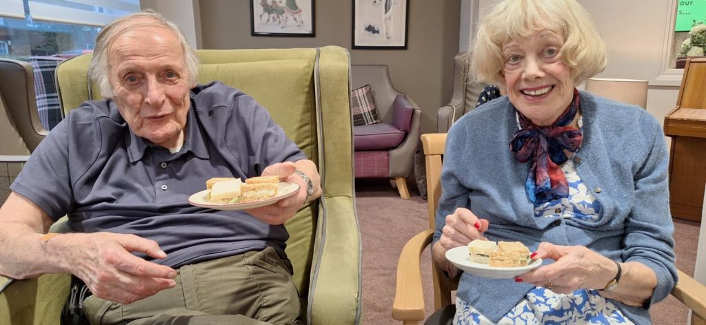 Two residents enjoying National Sandwich Day together at Spring Lane Care Home.