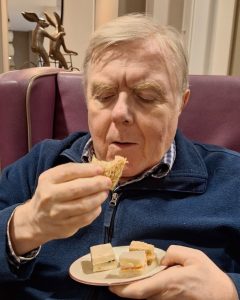 Close up of resident enjoying a sandwich during Spring Lane Care Home activity.