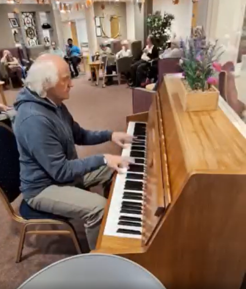 resident plays piano at care home