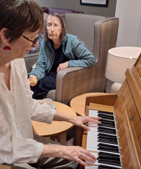 Visitor playing piano during World Piano Day event at Springdene Care Homes