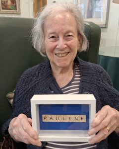 Resident proudly displaying personalised Scrabble artwork during World Scrabble Day at Spring Grove Care Home.