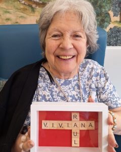 Resident showing personalised Scrabble-inspired artwork created during World Scrabble Day activities.