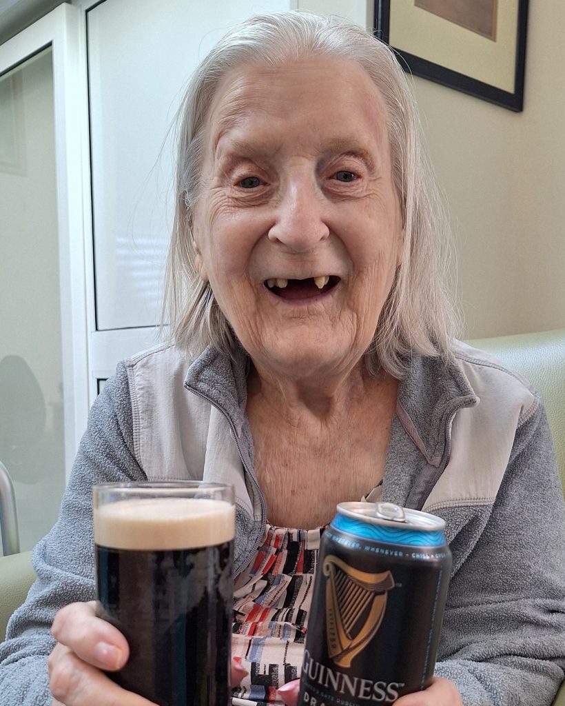 Resident enjoying a traditional glass of Guinness during St Patrick's Day celebrations at Springdene Care Homes.