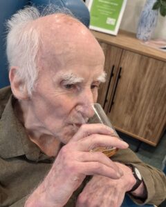 Resident sampling a beer during a sensory tasting activity at Springdene Care Homes