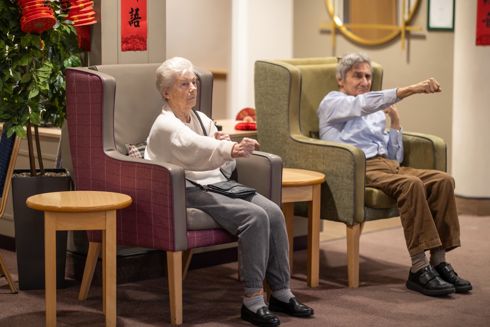Photo-006 (Large) Two residents taking part in a seated exercise activity at Springdene Care Home.