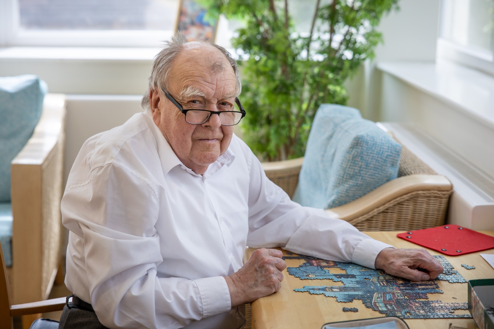 Photo-053 (Large) Resident enjoying a jigsaw puzzle at a table in a bright lounge at Springdene Care Home.