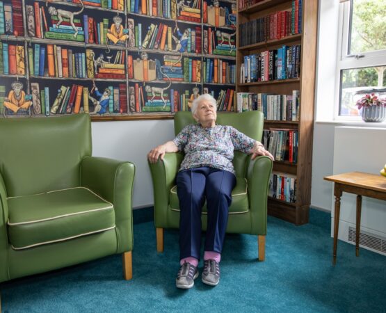 Photo-100 (Large) resident relaxing in the library at Springview care home