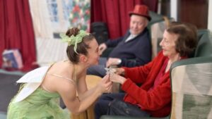 Resident enjoying a fairy-themed performance at Springdene Care Homes during a summer activity session.