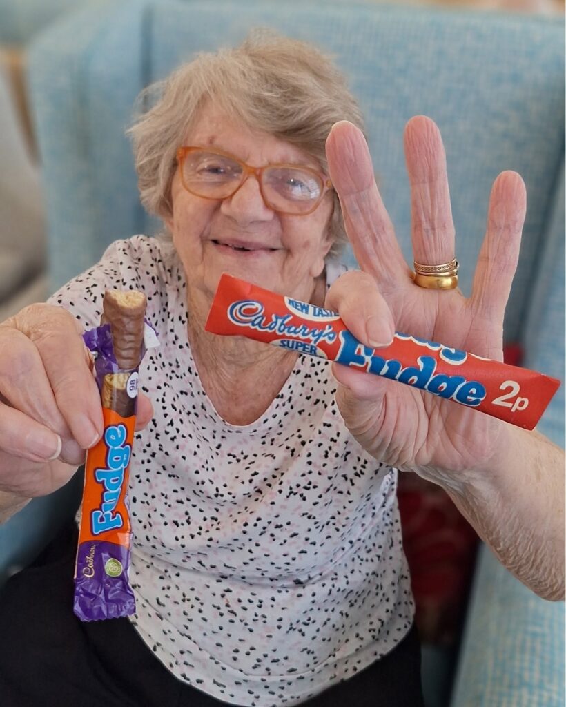 Springdene resident holding classic Cadbury chocolate bars during a World Chocolate Day tasting.